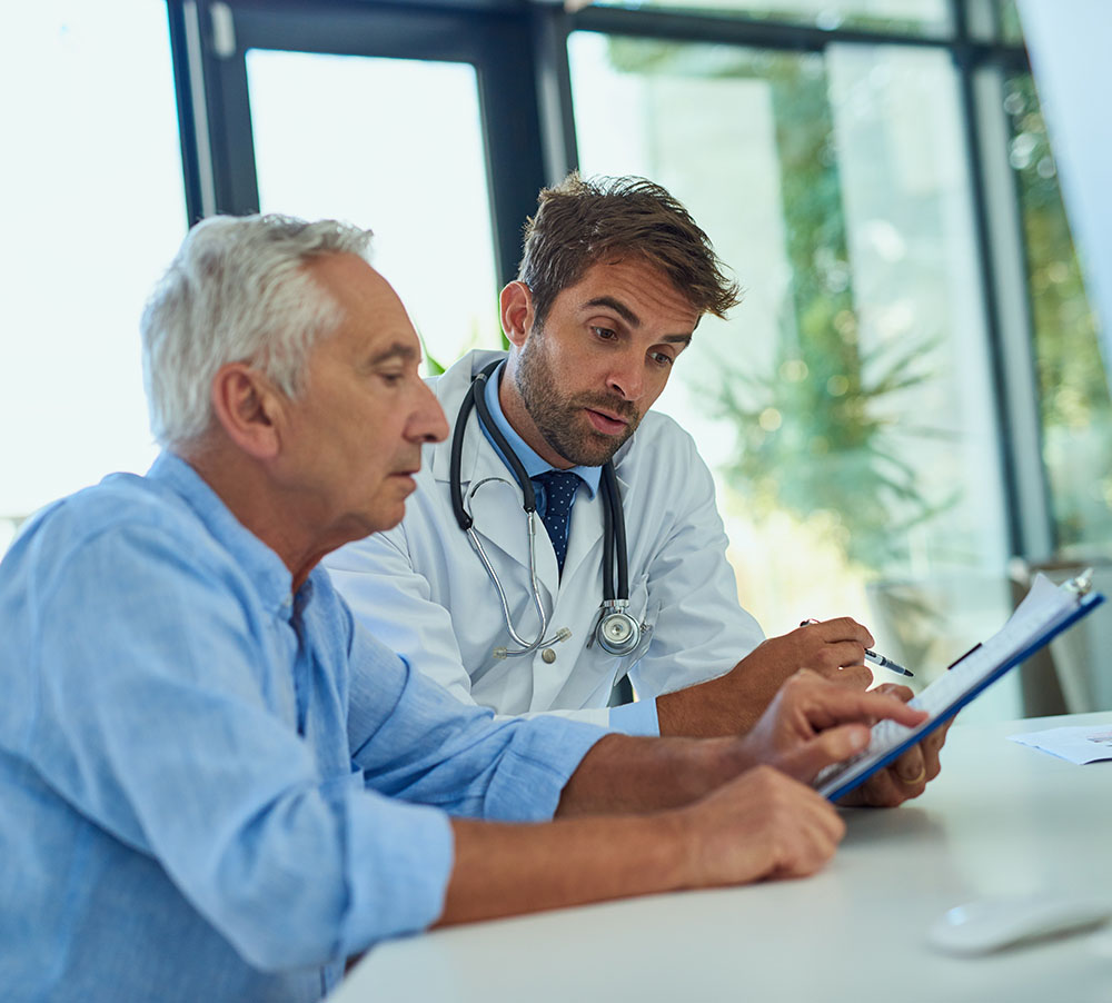 Shot of a doctor going over some paperwork with a male senior patient in a clinic.