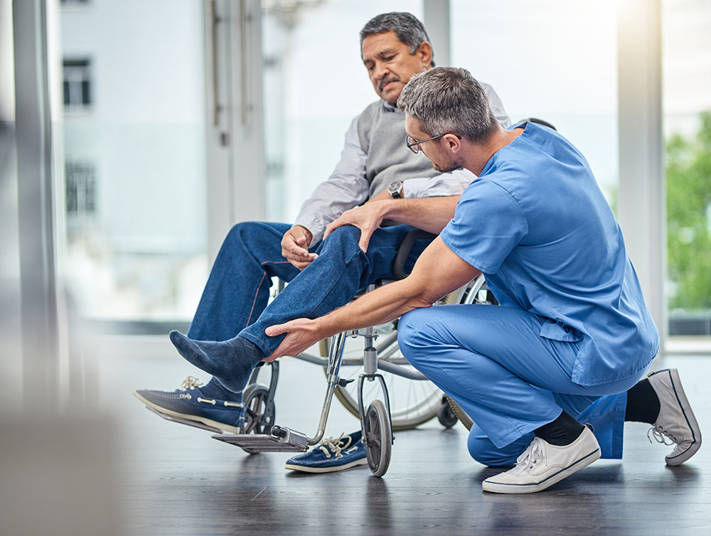 Shot of a nurse helping a senior man in a wheelchair.